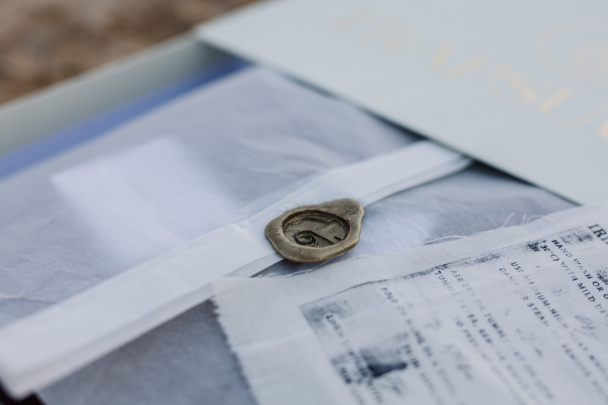 A close-up of a vintage-style wax seal from the Trapsuutjie Box, containing a Wrapped and sealed Shirt